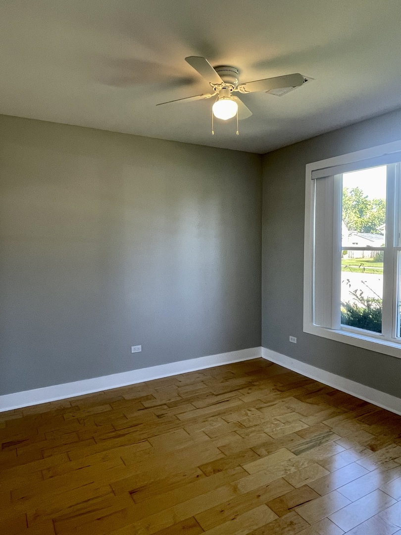 1986 Pine Street, Unit 1 Des Plaines, IL 60018 - Photo 8 of 11 a view of an empty room with window and chandelier fan