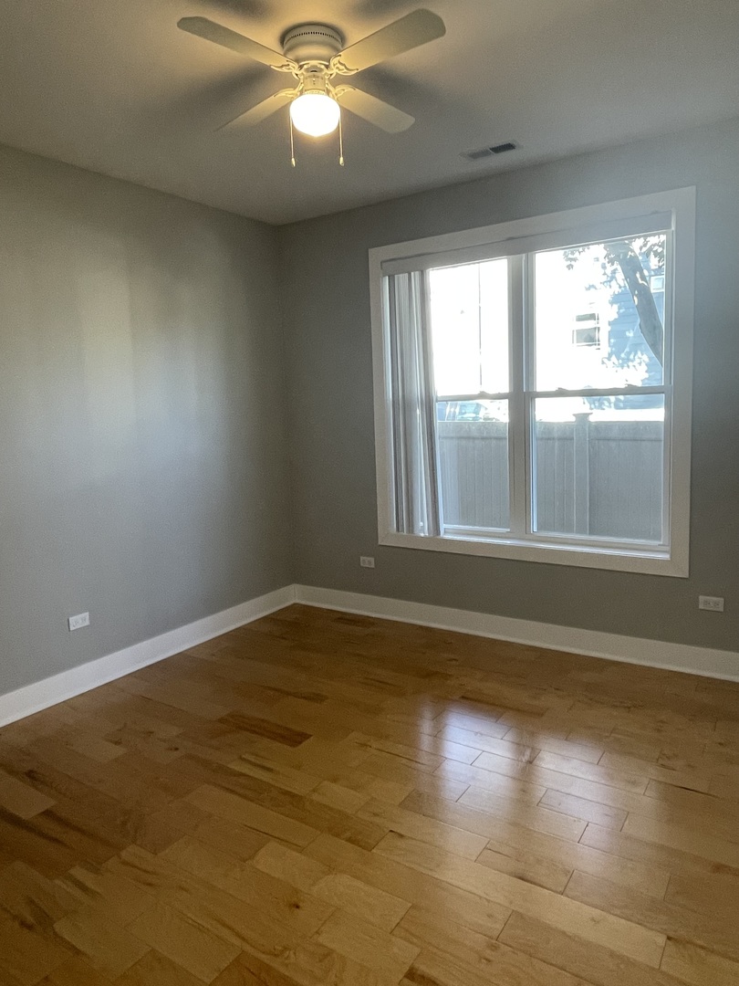 1986 Pine Street, Unit 1 Des Plaines, IL 60018 - Photo 9 of 11 a view of an empty room with wooden floor and a window