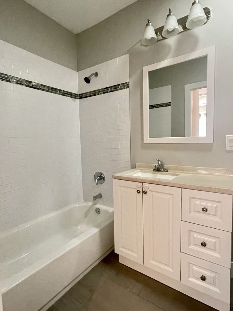 1986 Pine Street, Unit 1 Des Plaines, IL 60018 - Photo 10 of 11 a bathroom with a bathtub shower sink and mirror