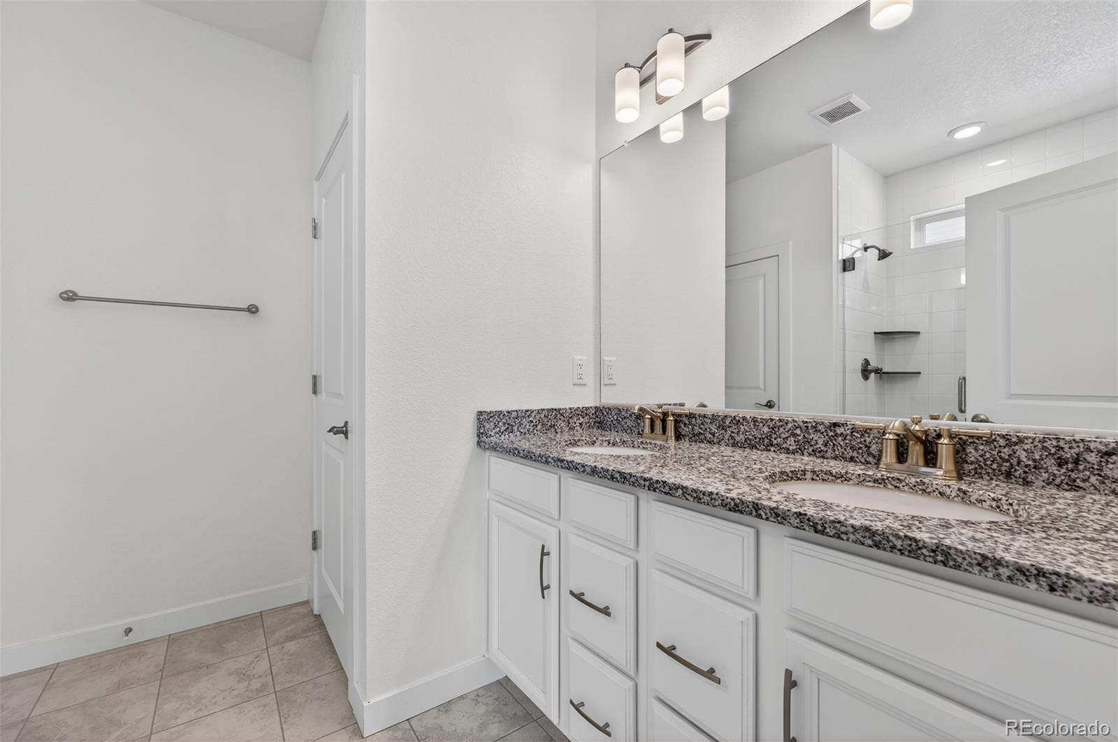 6311 Stable View Street Castle Pines, CO 80108 - Photo 16 of 46 a bathroom with a granite countertop sink and a mirror