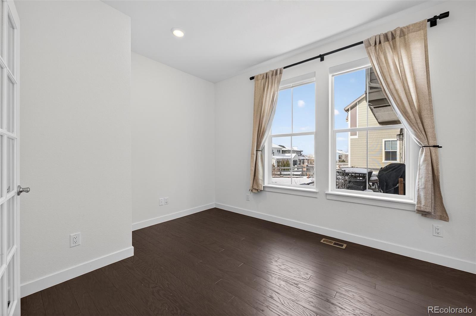 6311 Stable View Street Castle Pines, CO 80108 - Photo 19 of 46 an empty room with wooden floor and windows