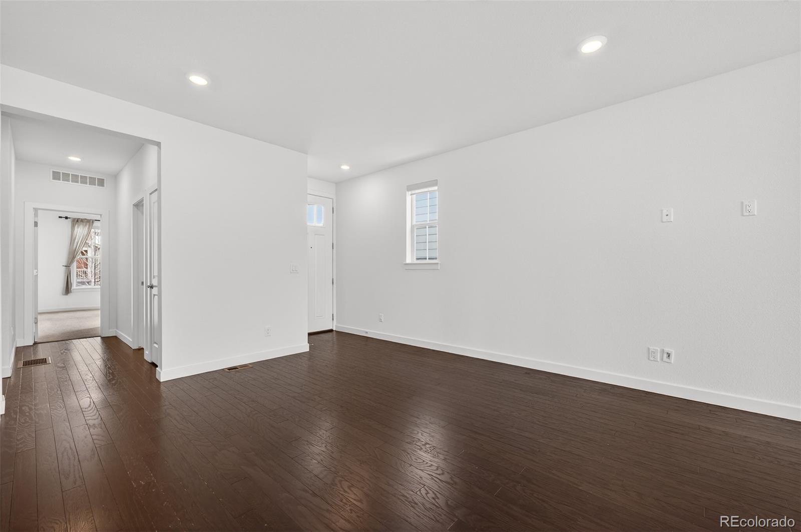 6311 Stable View Street Castle Pines, CO 80108 - Photo 5 of 46 an empty room with wooden floor and windows
