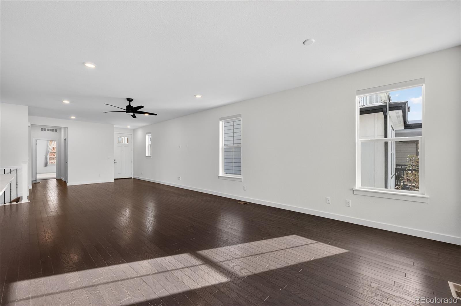 6311 Stable View Street Castle Pines, CO 80108 - Photo 6 of 46 an empty room with wooden floor and windows