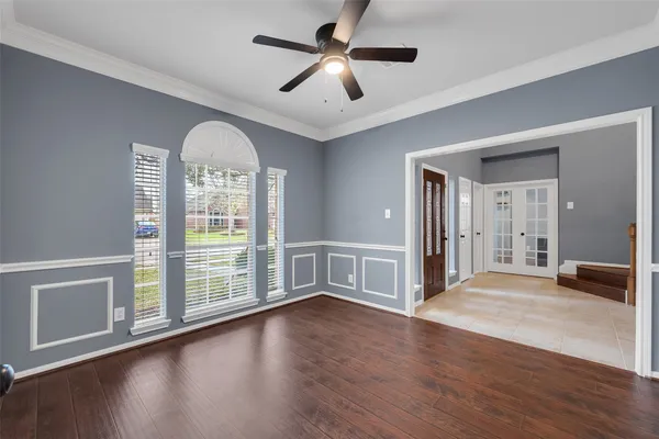 a view of an empty room with window and wooden floor