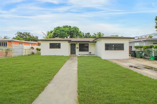 a front view of house with yard and green space