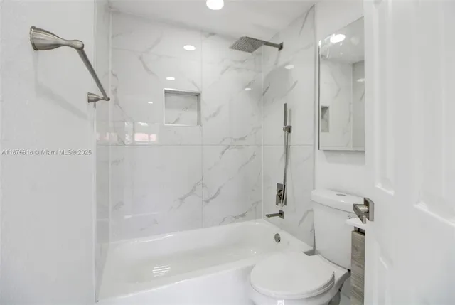 a bathroom with a bathtub shower sink vanity and toilet