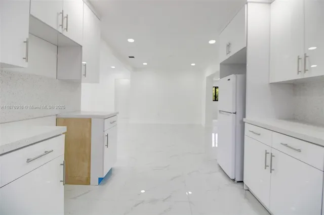 a view of a kitchen with white cabinets