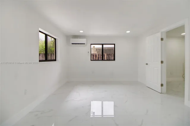 an empty room with windows and closet