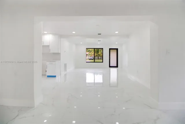 a view of a hallway with wooden floor and windows