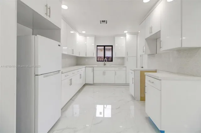 a kitchen with white cabinets and white appliances