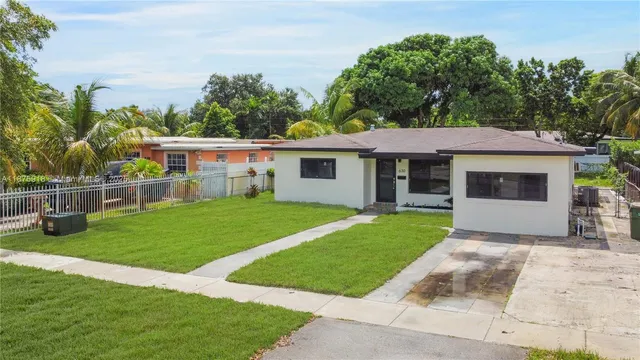 a view of a house with a yard and sitting area