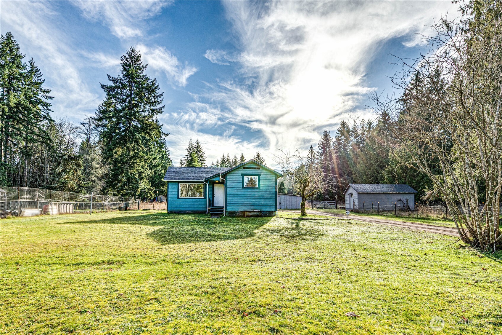 a view of a house with a big yard and large trees