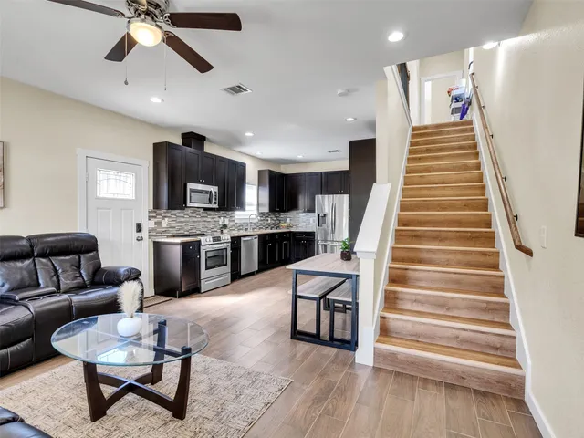a living room with furniture and a wooden floor