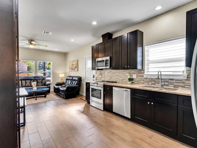 a large kitchen with stainless steel appliances granite countertop a stove and cabinets