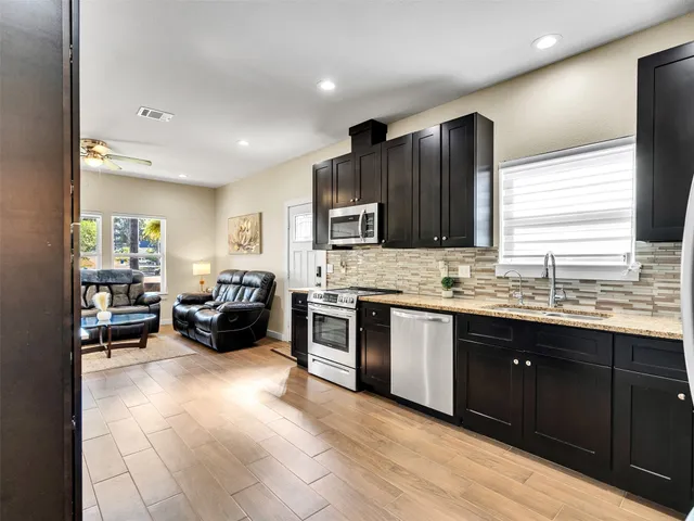 a kitchen with stainless steel appliances granite countertop a sink and stove