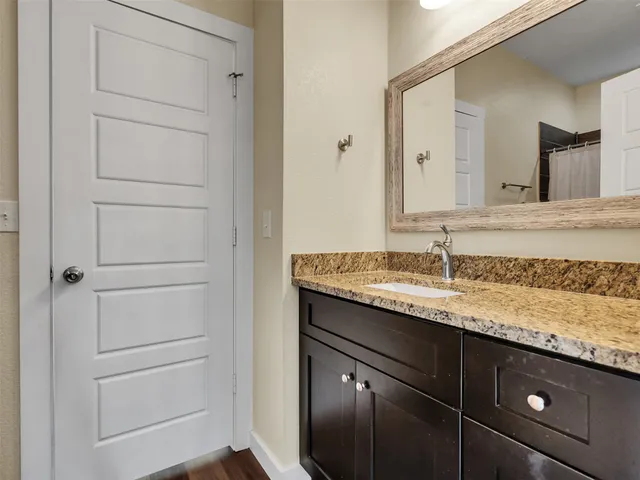 a bathroom with a granite countertop sink and a mirror