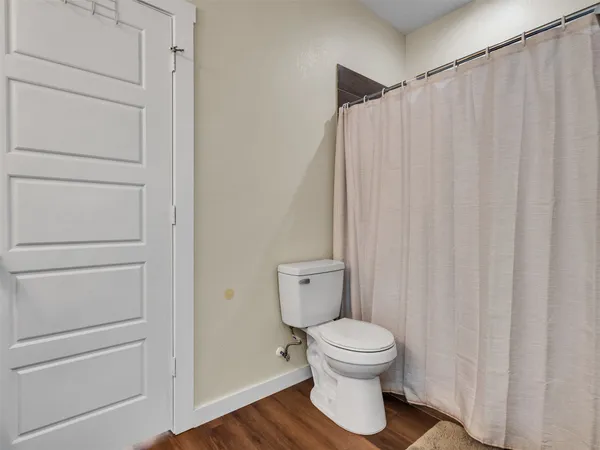 a bathroom with a toilet and a shower curtain