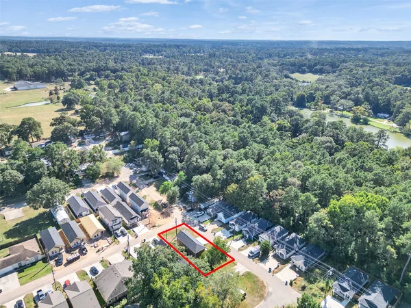 an aerial view of residential houses with outdoor space and trees