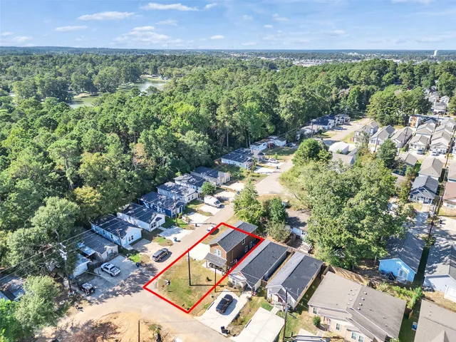 an aerial view of a house with a yard and lake view