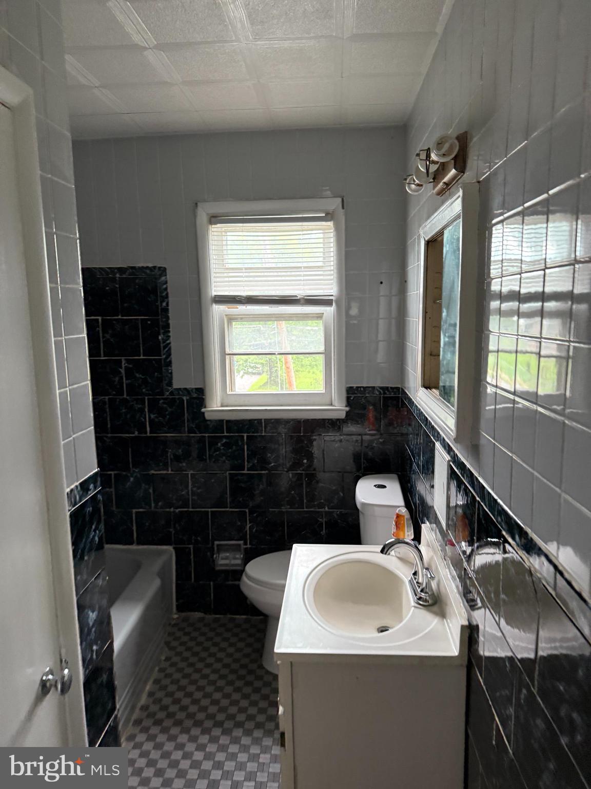 3901 Mortimer Avenue Baltimore, MD 21215 - Photo 12 of 21 a bathroom with a sink toilet a tub and window
