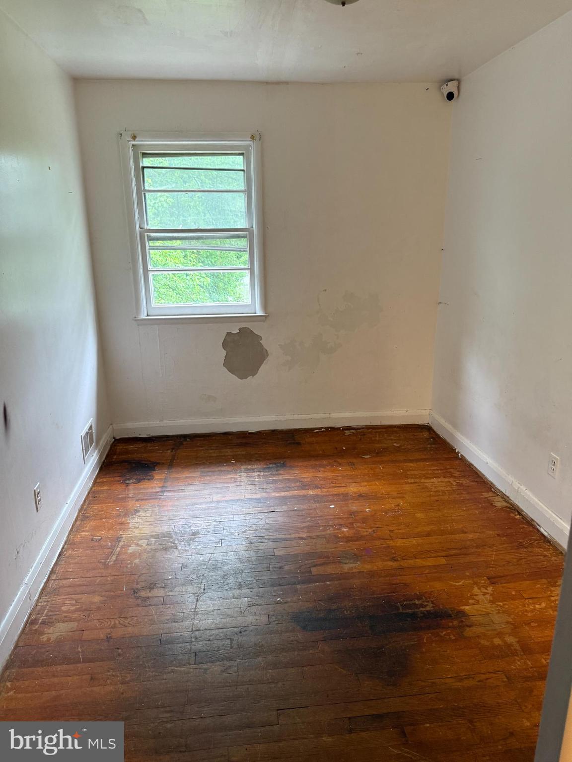 3901 Mortimer Avenue Baltimore, MD 21215 - Photo 9 of 21 an empty room with wooden floor and windows