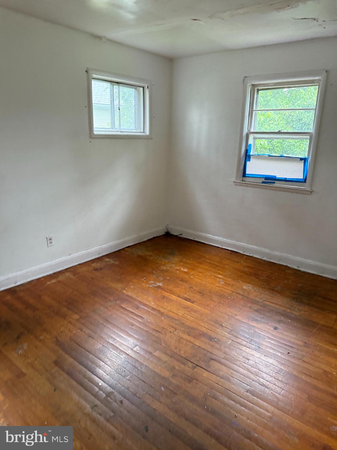3901 Mortimer Avenue Baltimore, MD 21215 - Photo 10 of 21 an empty room with wooden floor and windows