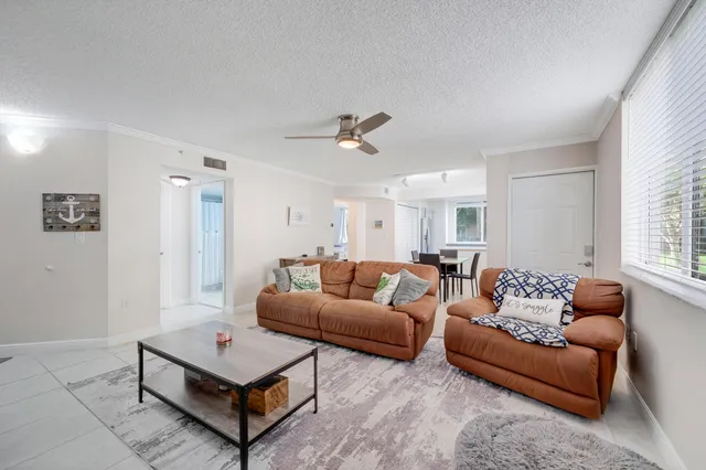 a living room with furniture a ceiling fan and a window