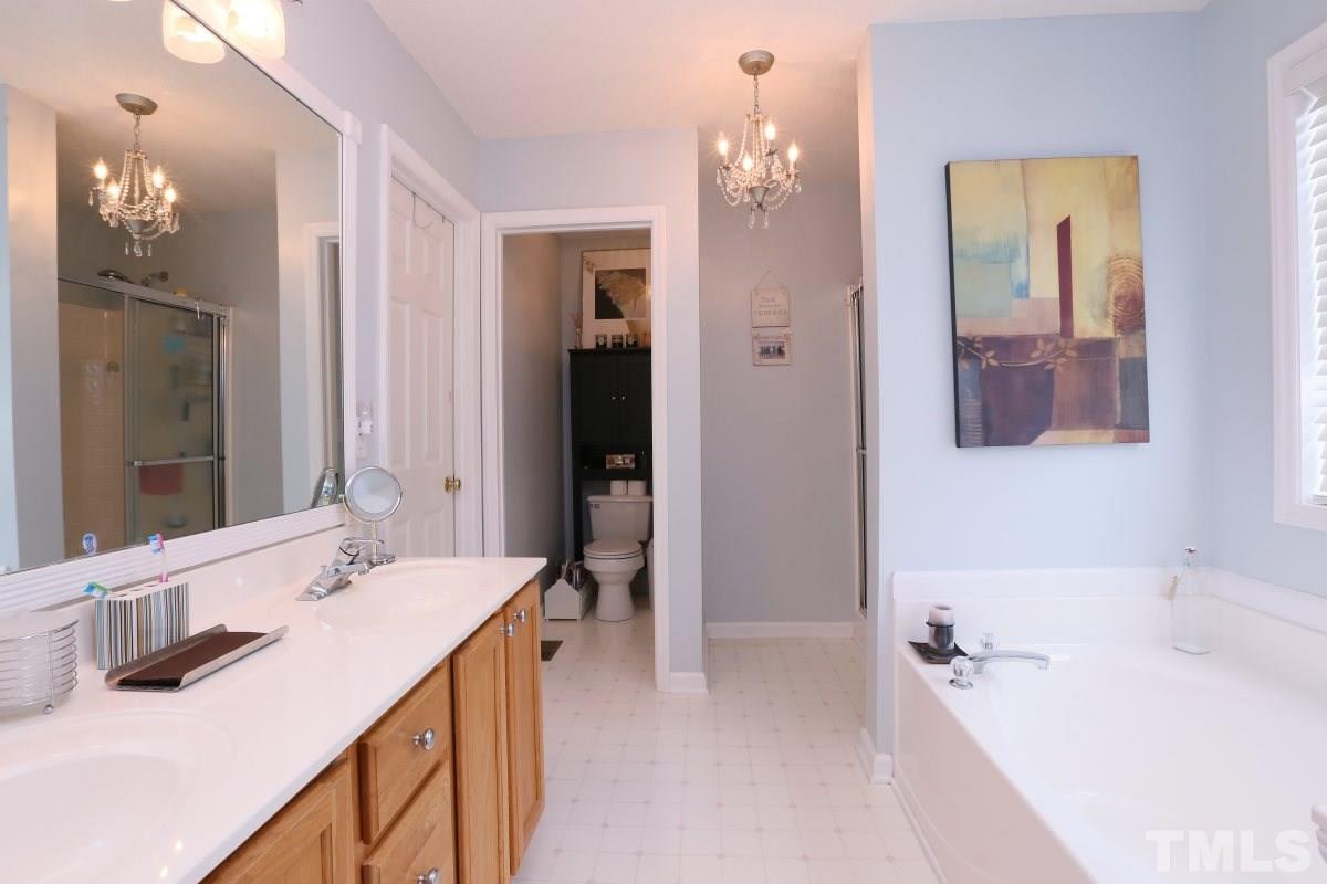 4033 Mantua Way Raleigh, NC 27604 - Photo 15 of 23 a bathroom with a tub a sink and mirror