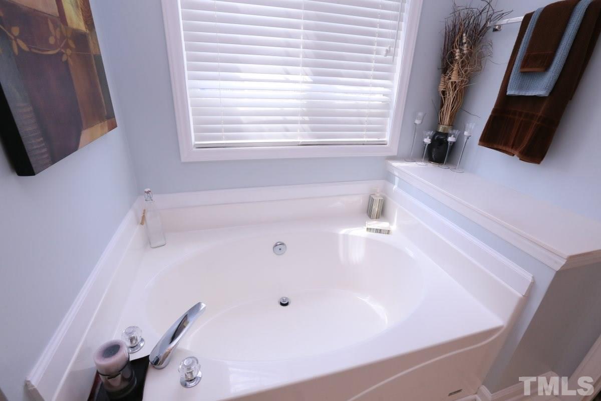 4033 Mantua Way Raleigh, NC 27604 - Photo 16 of 23 a bathroom with a tub a sink and a large window