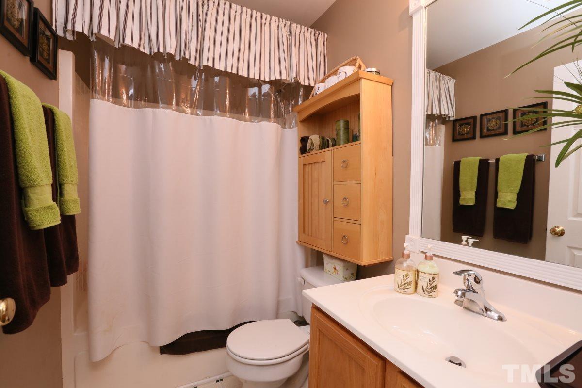 4033 Mantua Way Raleigh, NC 27604 - Photo 19 of 23 a bathroom with a sink a toilet and shower