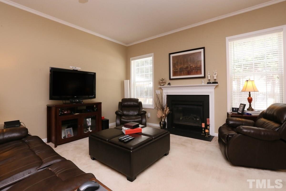4033 Mantua Way Raleigh, NC 27604 - Photo 5 of 23 a living room with furniture a flat screen tv and a fireplace