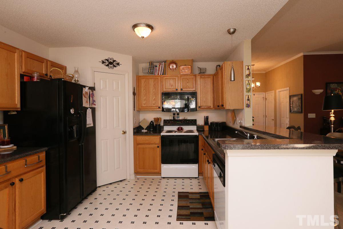 4033 Mantua Way Raleigh, NC 27604 - Photo 7 of 23 a kitchen with granite countertop a refrigerator stove and sink