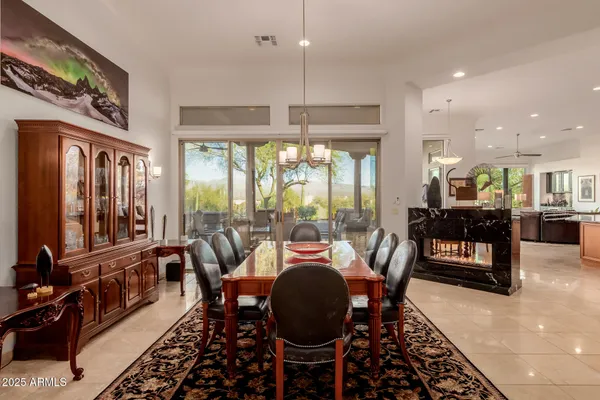 a dining room with furniture a chandelier and wooden floor