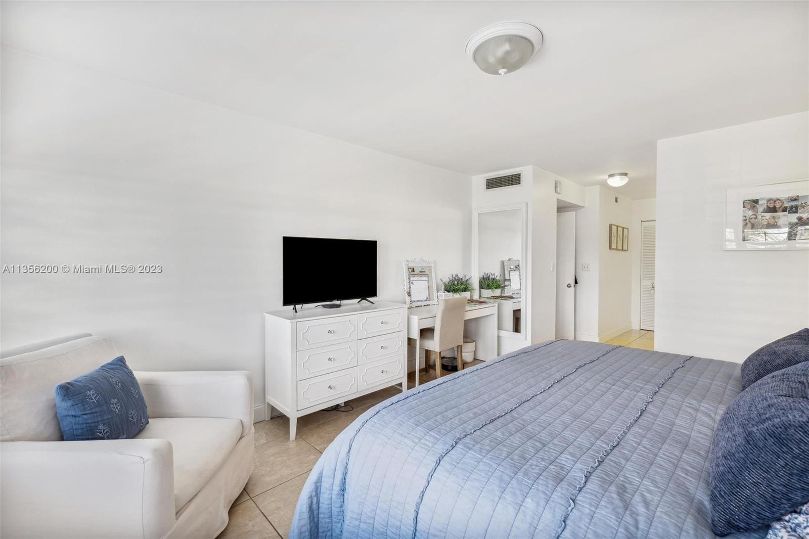 550 Ocean Drive, Unit 5C Key Biscayne, FL 33149 - Photo 14 of 21 a bedroom with a bed a couch and a flat screen tv