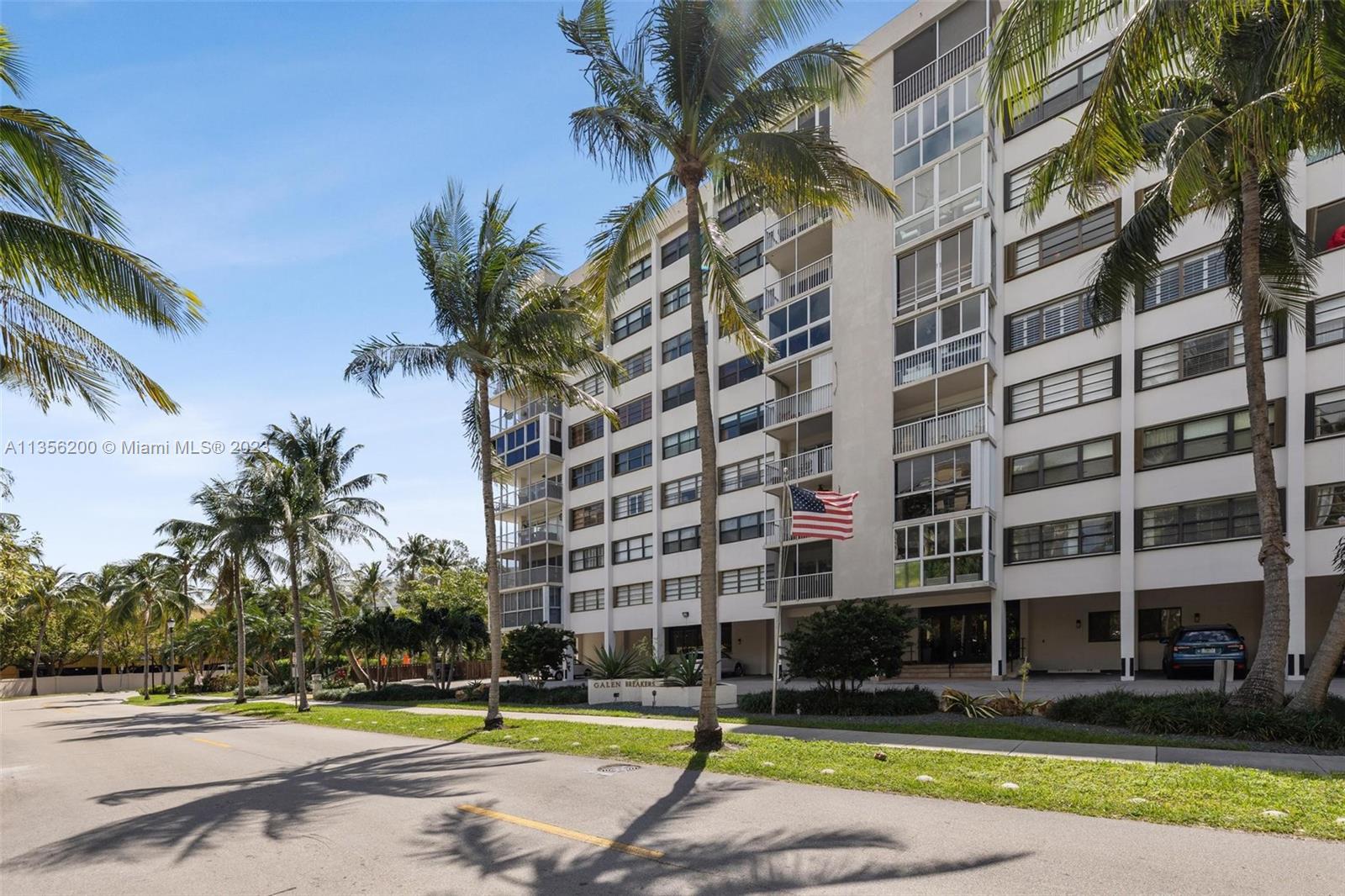 550 Ocean Drive, Unit 5C Key Biscayne, FL 33149 - Photo 16 of 21 a view of a swimming pool with a lawn chairs and palm trees