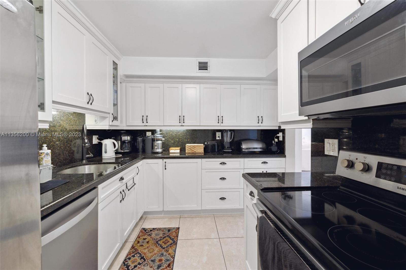 550 Ocean Drive, Unit 5C Key Biscayne, FL 33149 - Photo 6 of 21 a kitchen with stainless steel appliances granite countertop a stove a sink and a microwave
