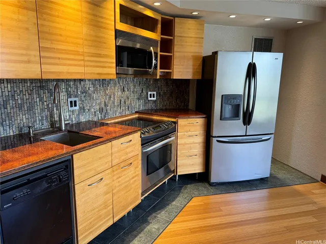 a kitchen with stainless steel appliances granite countertop a sink a stove and a refrigerator