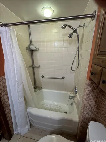 a white toilet sitting next to a bath tub and a shower