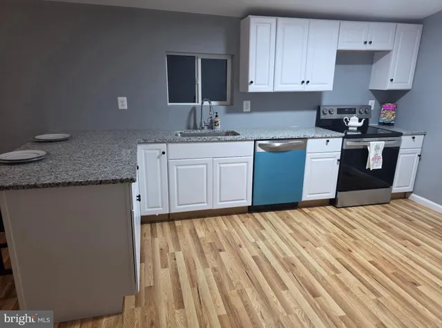 a kitchen with granite countertop a sink stainless steel appliances and cabinets