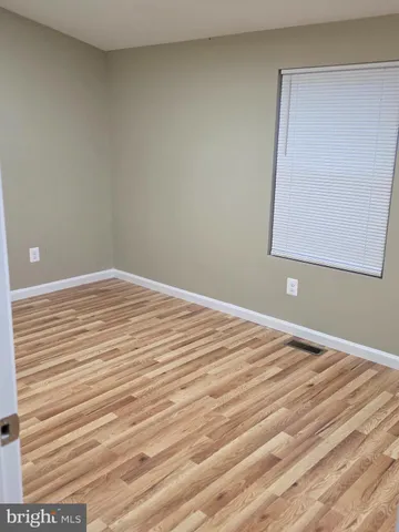 a view of a room with wooden floor and cabinet