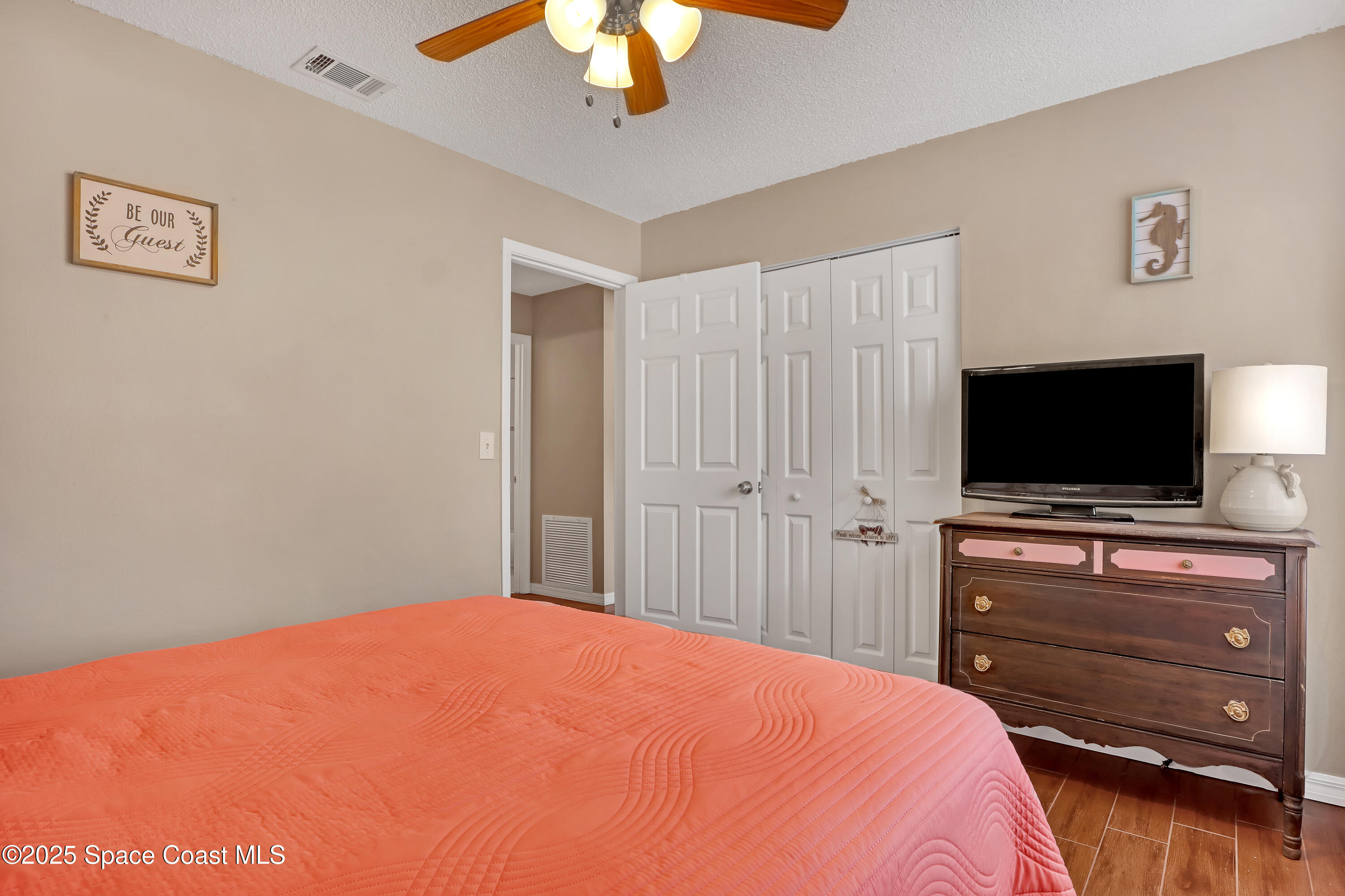 1513 Creel Road Northeast Palm Bay, FL 32905 - Photo 17 of 31 a bedroom with a bed and a flat screen tv