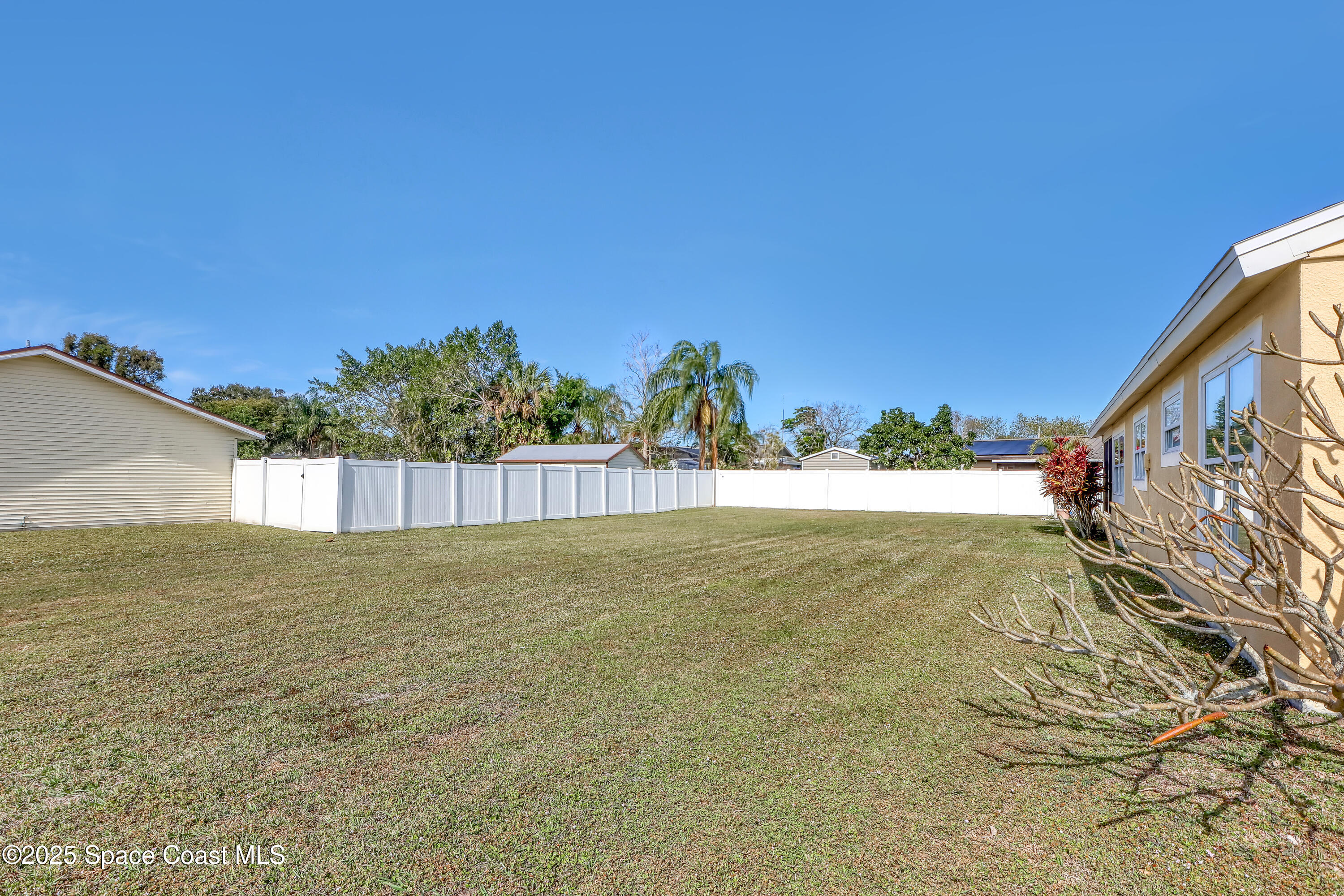 1513 Creel Road Northeast Palm Bay, FL 32905 - Photo 25 of 31 a view of yard with swimming pool and wooden fence