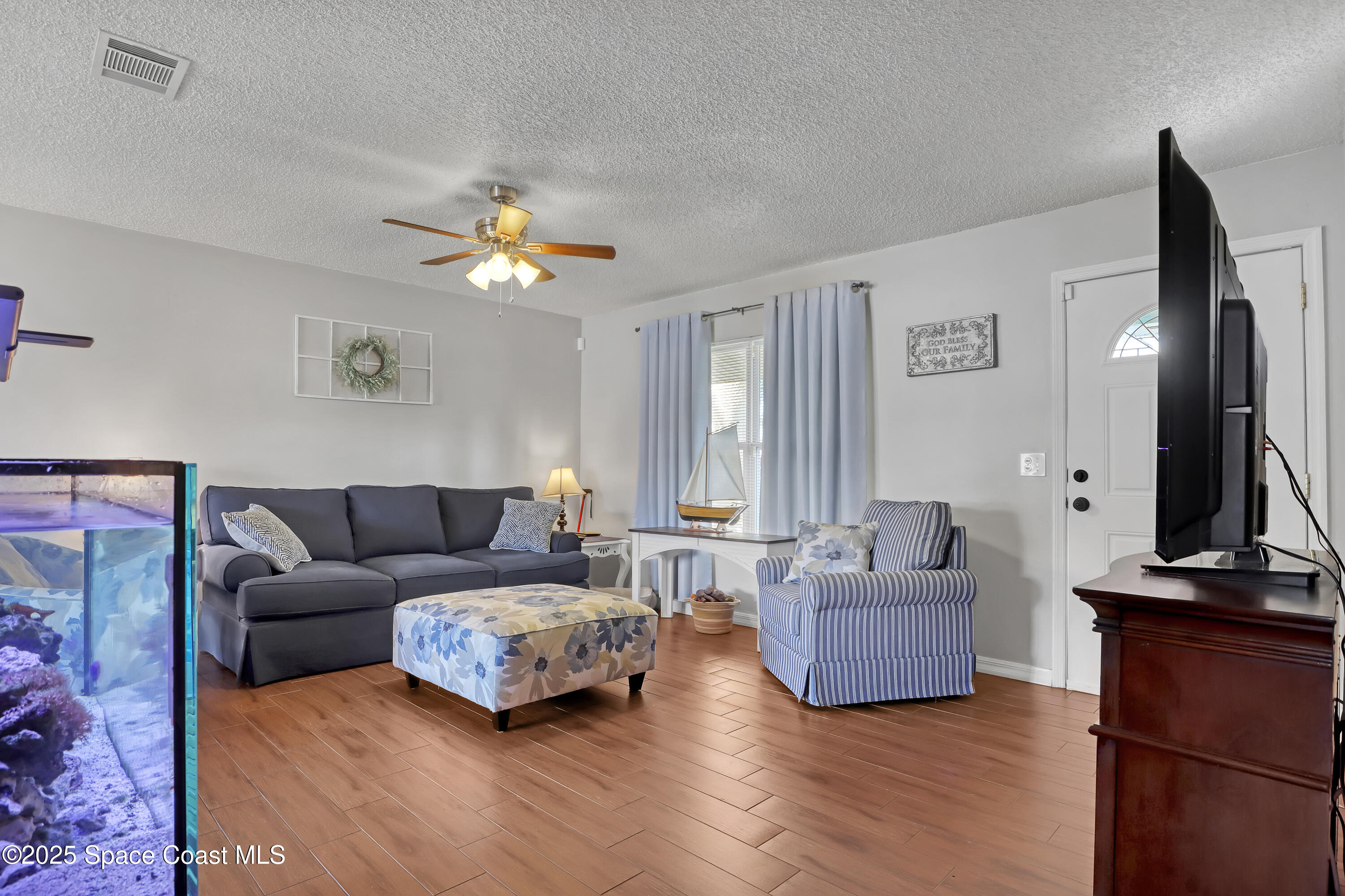 1513 Creel Road Northeast Palm Bay, FL 32905 - Photo 4 of 31 a living room with furniture and a flat screen tv