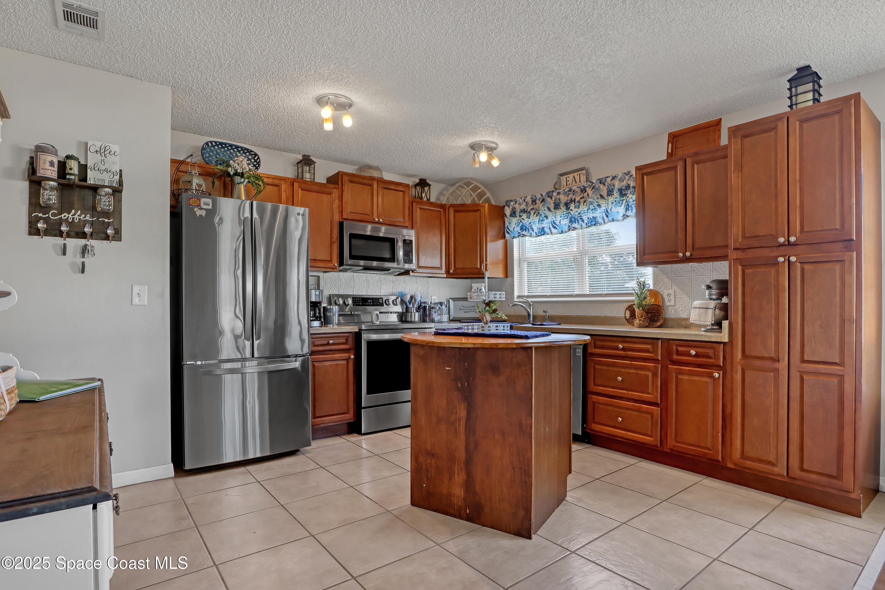 1513 Creel Road Northeast Palm Bay, FL 32905 - Photo 9 of 31 a kitchen with stainless steel appliances granite countertop a refrigerator and a stove top oven
