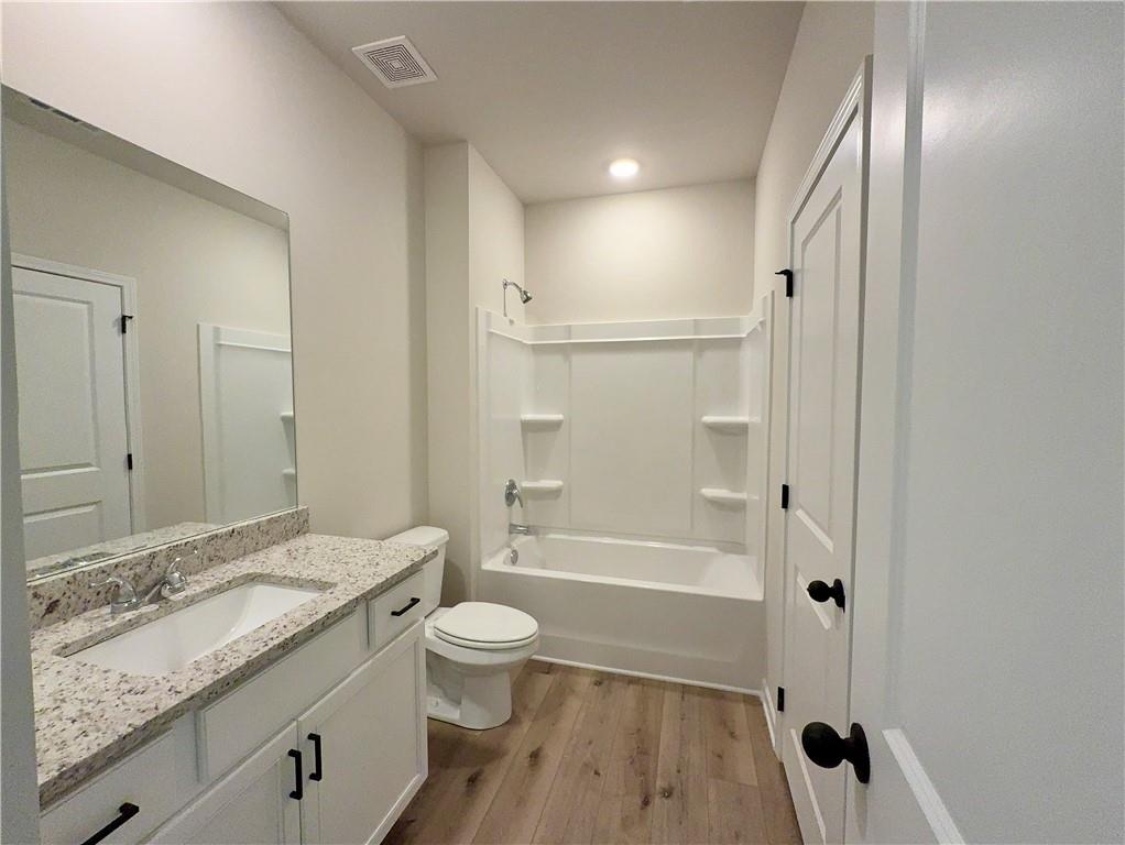 2225 Sun Valley Buford, GA 30519 - Photo 12 of 23 a bathroom with a granite countertop sink a toilet a mirror and bathtub