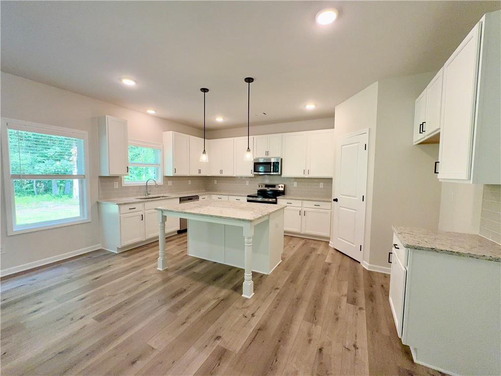 2225 Sun Valley Buford, GA 30519 - Photo 9 of 23 a kitchen with granite countertop a stove a sink dishwasher and a refrigerator with wooden floor