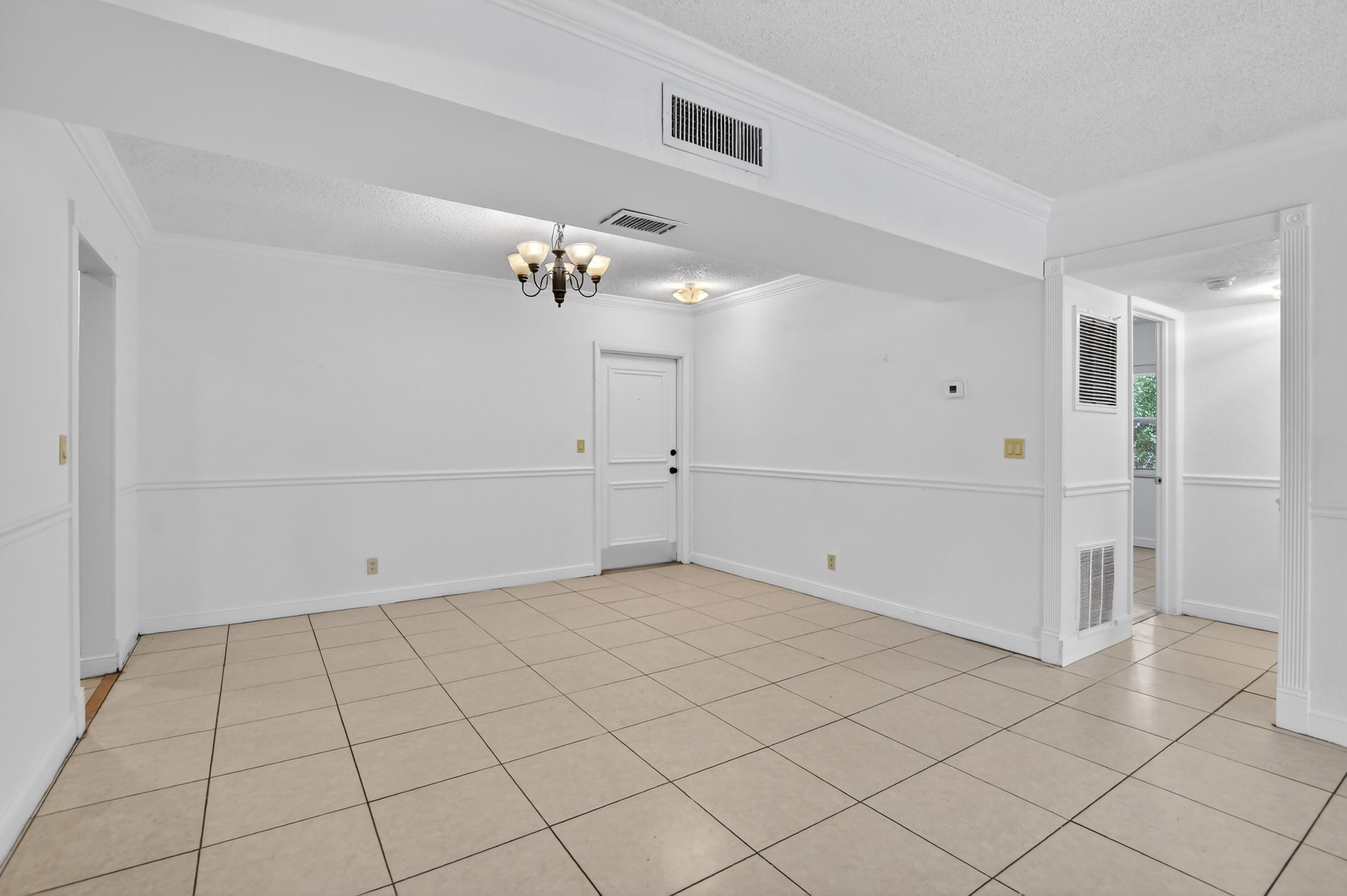 636 Northwest 13th Street, Unit 110 Boca Raton, FL 33486 - Photo 6 of 35 an empty room with chandelier fan and windows