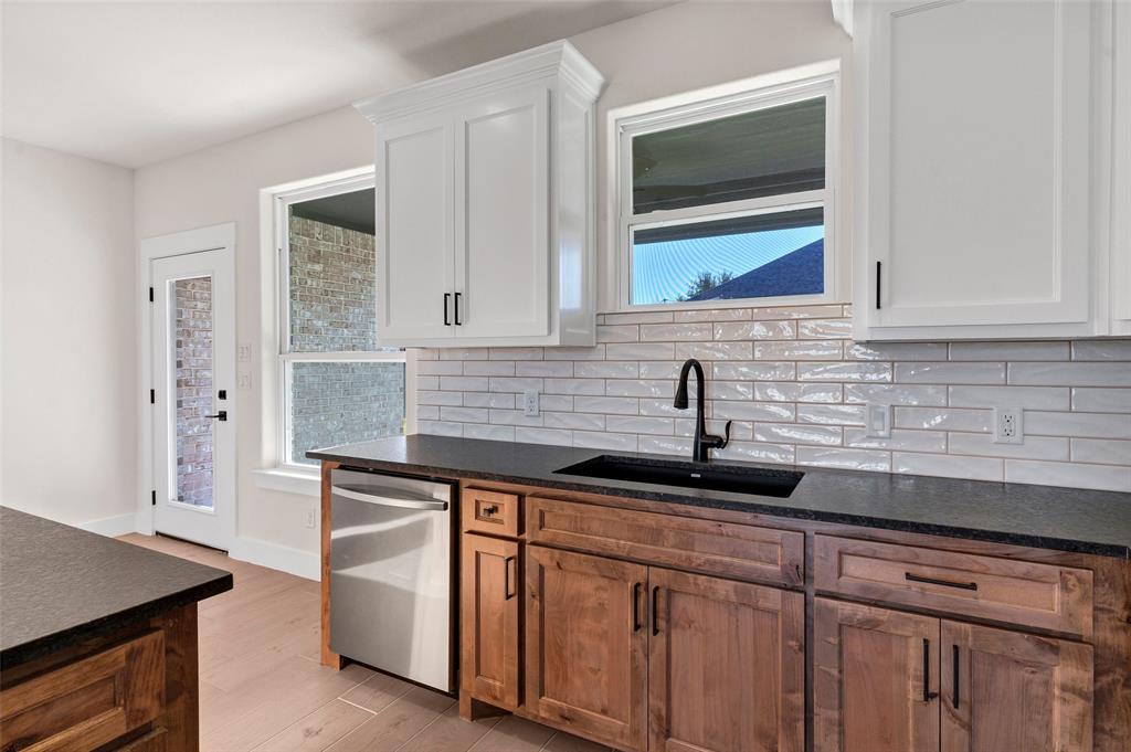 3306 Promenade Court Granbury, TX 76049 - Photo 15 of 40 a kitchen with a sink and cabinets