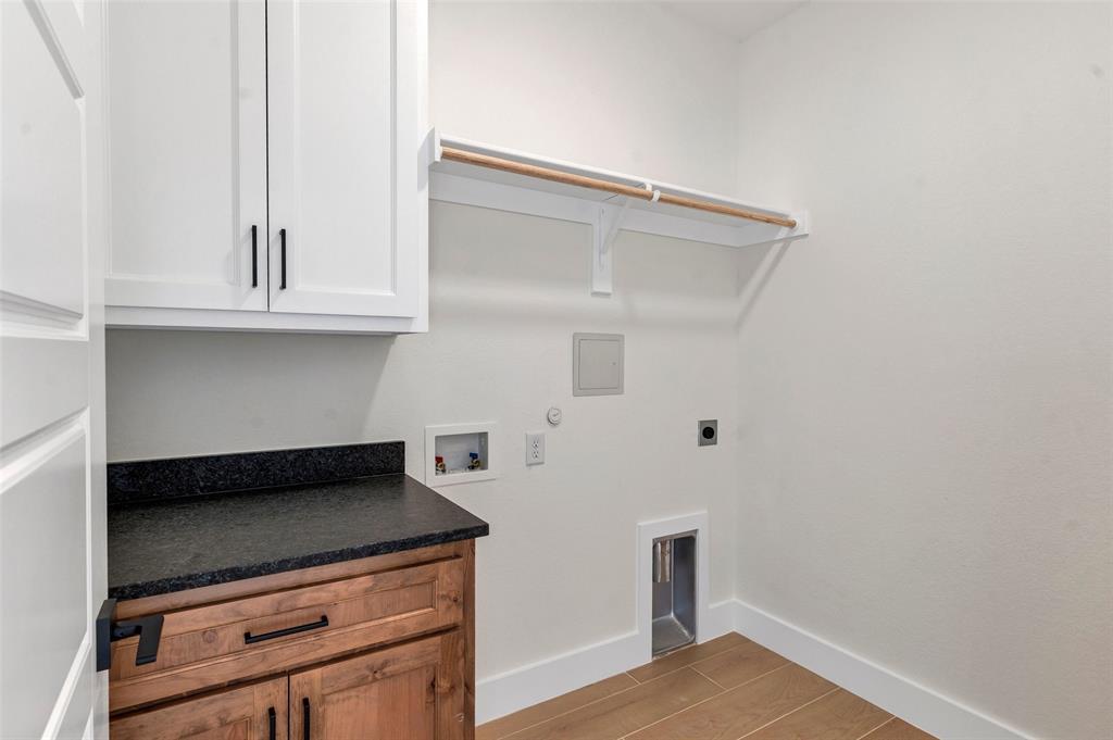 3306 Promenade Court Granbury, TX 76049 - Photo 20 of 40 a kitchen with granite countertop white cabinets and black appliances