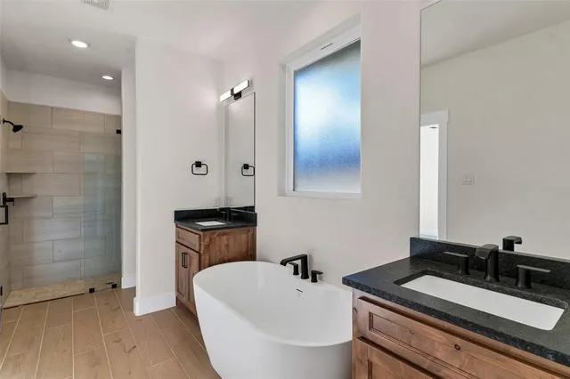 a bathroom with a tub sink and mirror